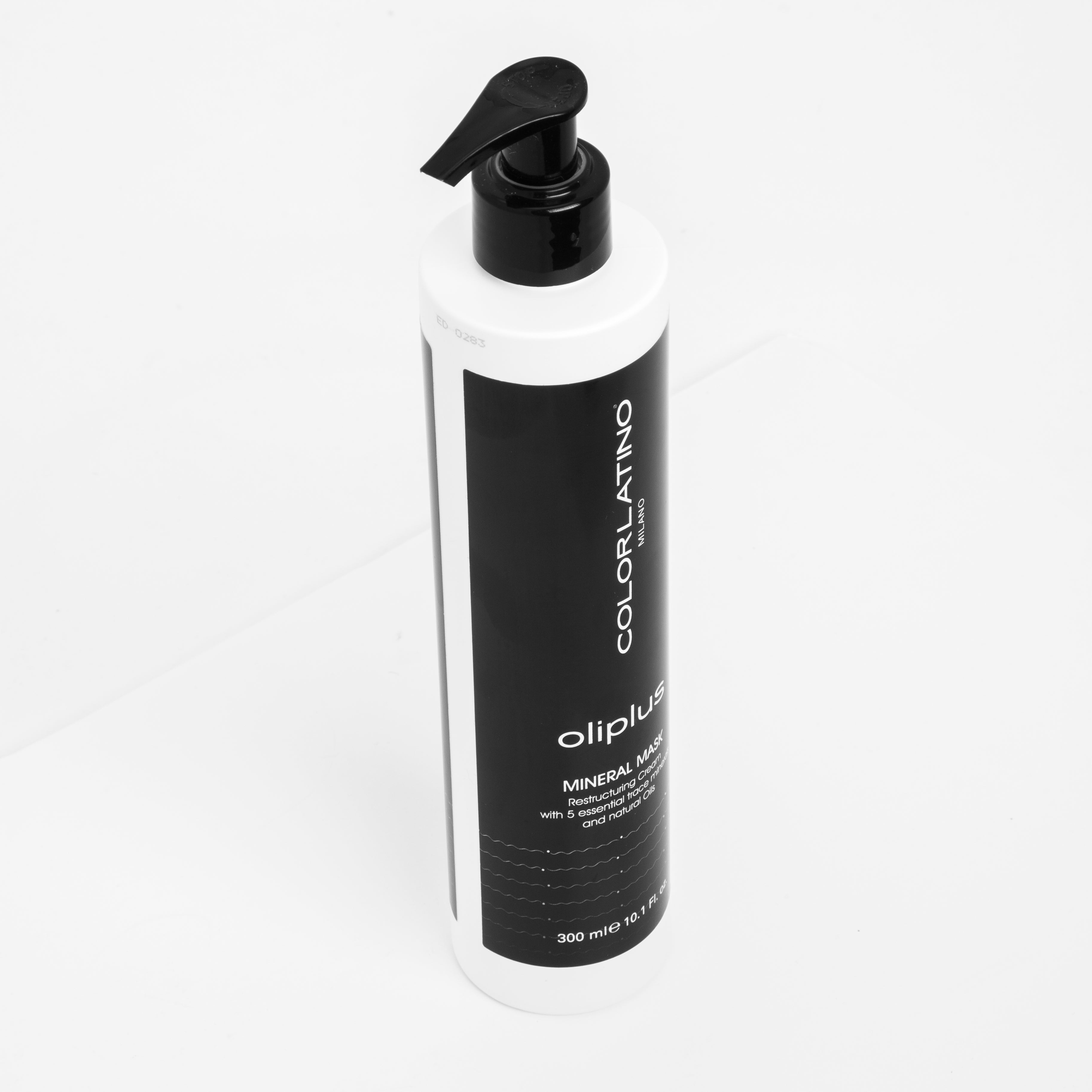 Black and white bottle of oliplus hair product on a white background